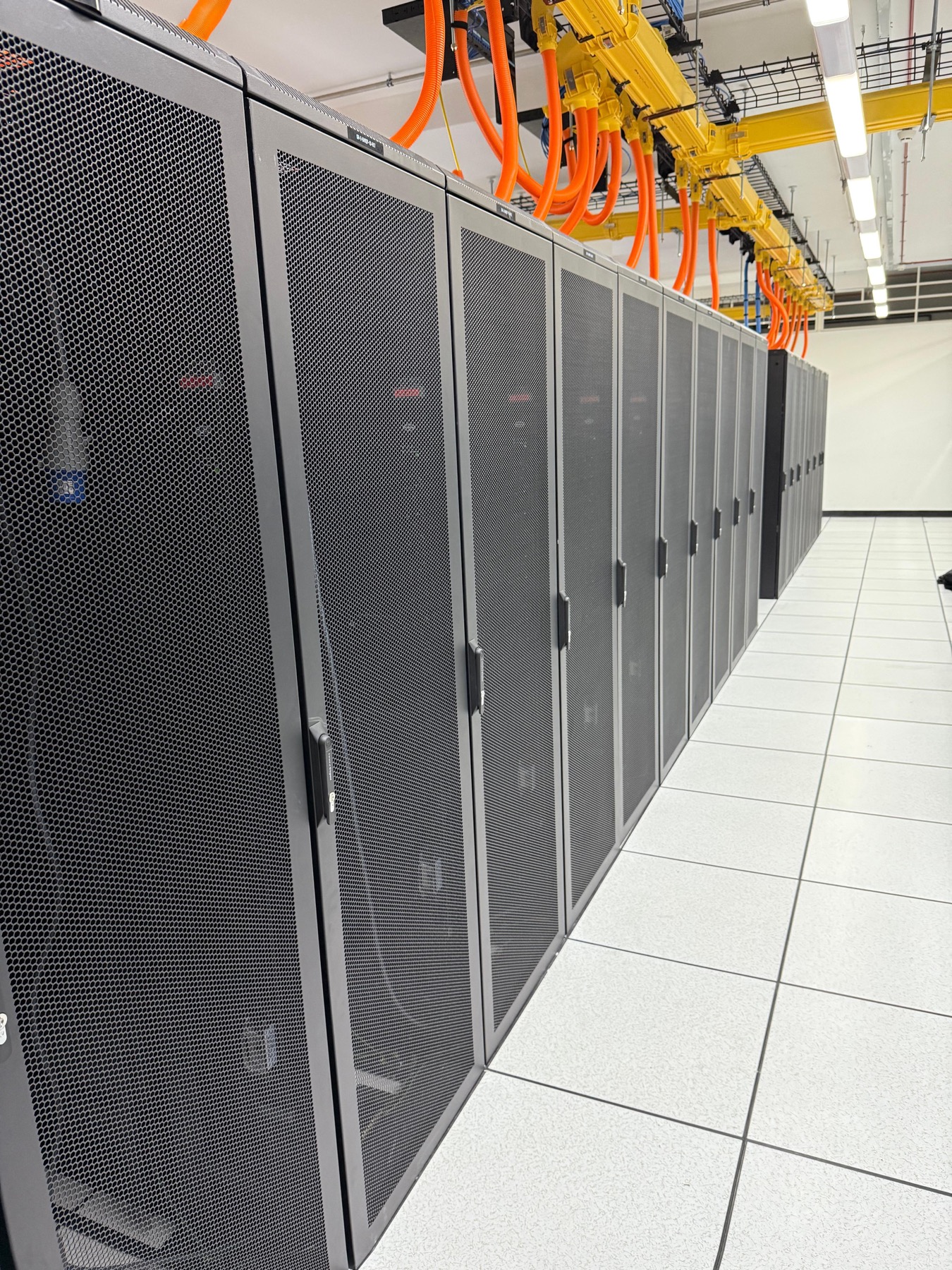Data center racks with overhead power busway and cabling