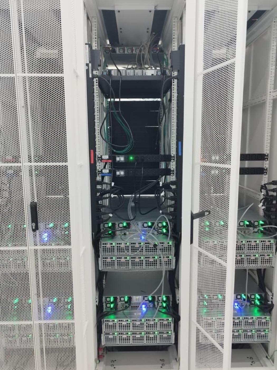 White server racks with deployed compute hardware and status lights